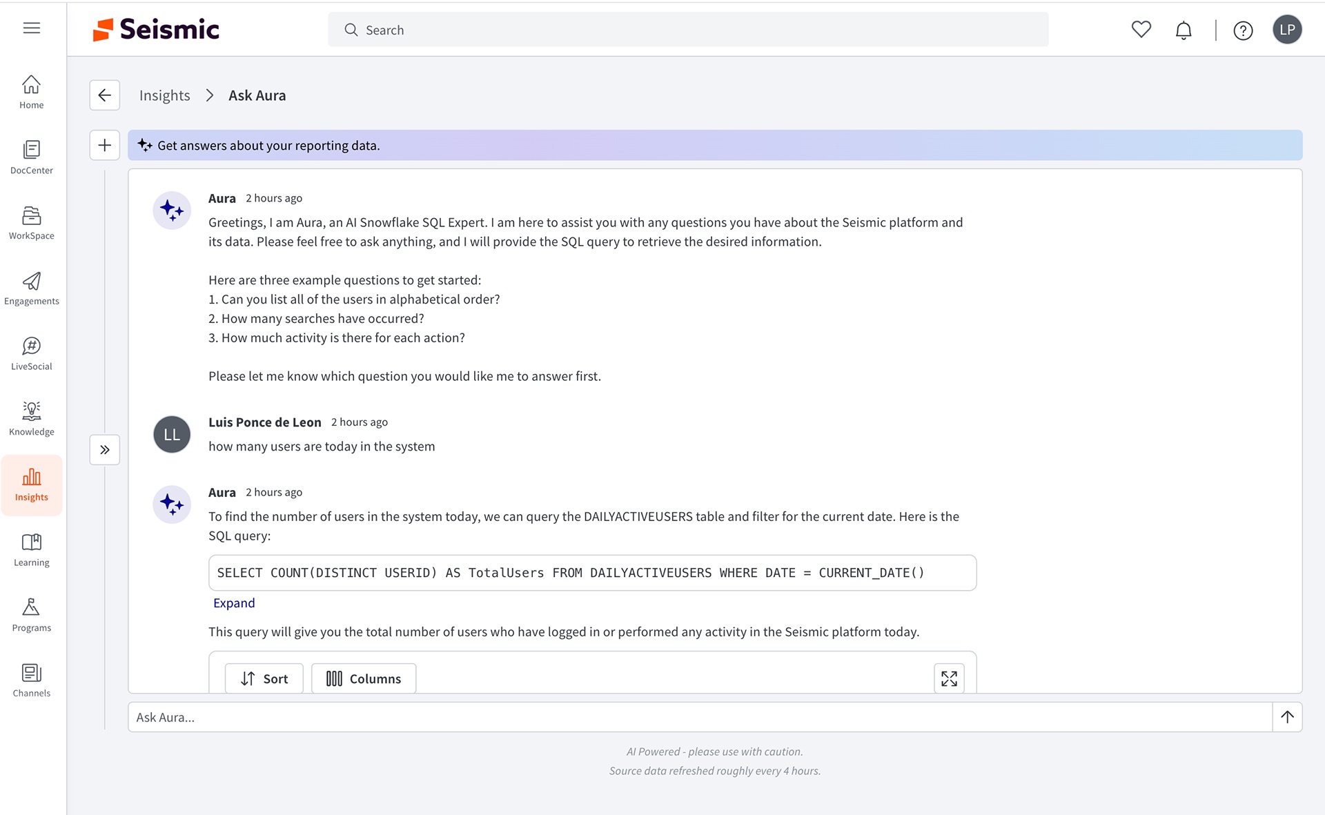 Shipped Ask Aura with the side panel collapsed, showing Aura's greeting with three example questions, a user question, and an answer with a one-line SQL query, Expand link, explanation and a results table with Sort and Columns